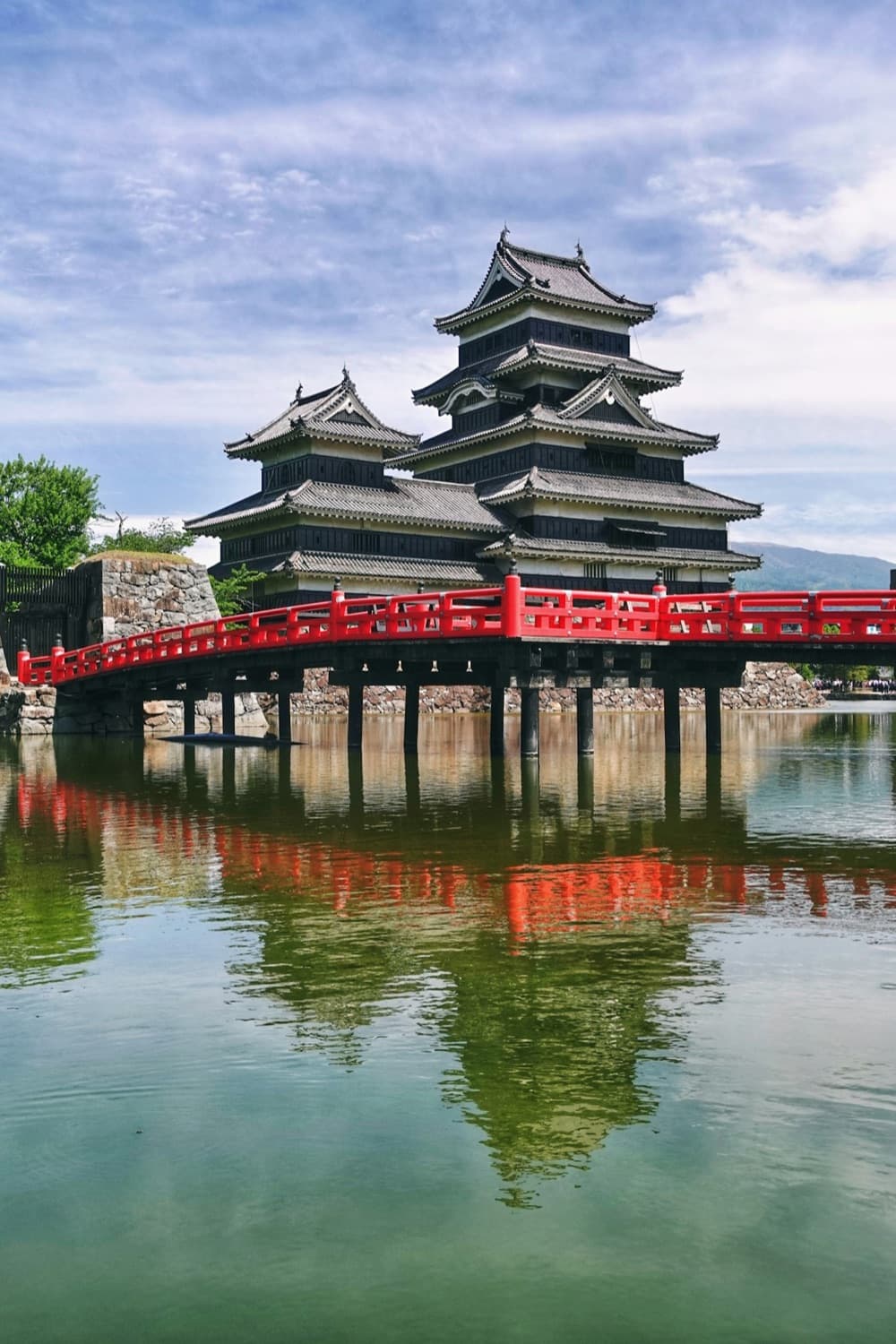 Il castello nero di Matsumoto con il ponte rosso che si specchia nel fossato