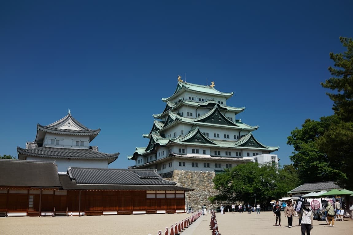 Il castello di Nagoya bianco e verde con i pesci d'oro (shachihoko) sul tetto, sotto un cielo azzurro