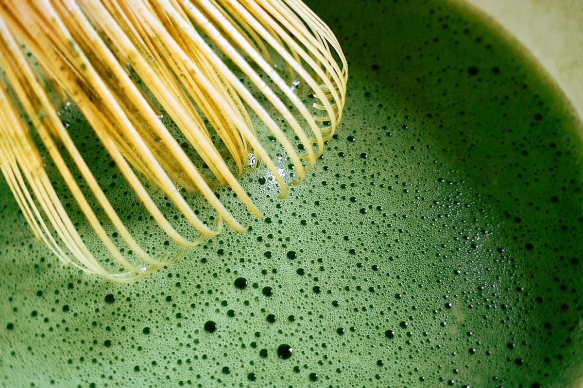 Matcha appena montato con la frusta di bambù, in primo piano