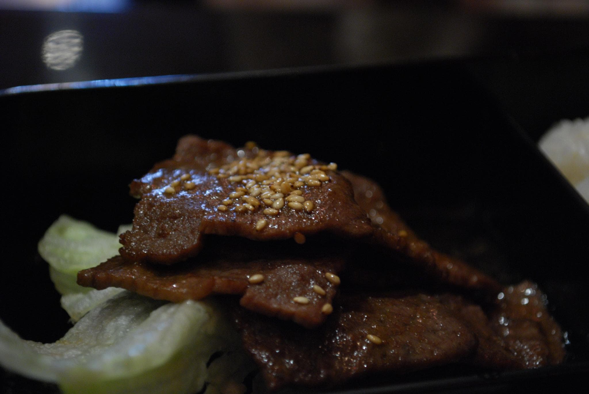 Yakiniku: fettine di manzo pregiate che cuociono sulla griglia rovente integrata nel tavolo di un ristorante giapponese