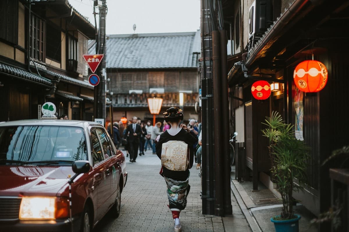 Una via di Gion al tramonto, con le lanterne rosse accese e le case in legno