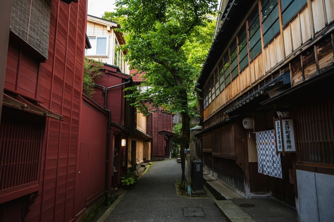 Un vicolo silenzioso del quartiere delle case da tè di Kanazawa, con case di legno e pareti rosse