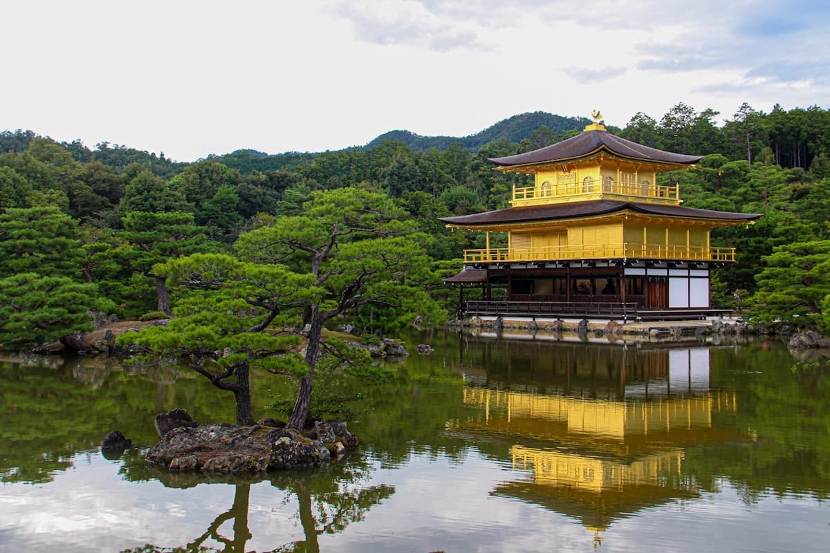 Il Padiglione d'Oro di Kyoto riflesso nello stagno, circondato dai pini