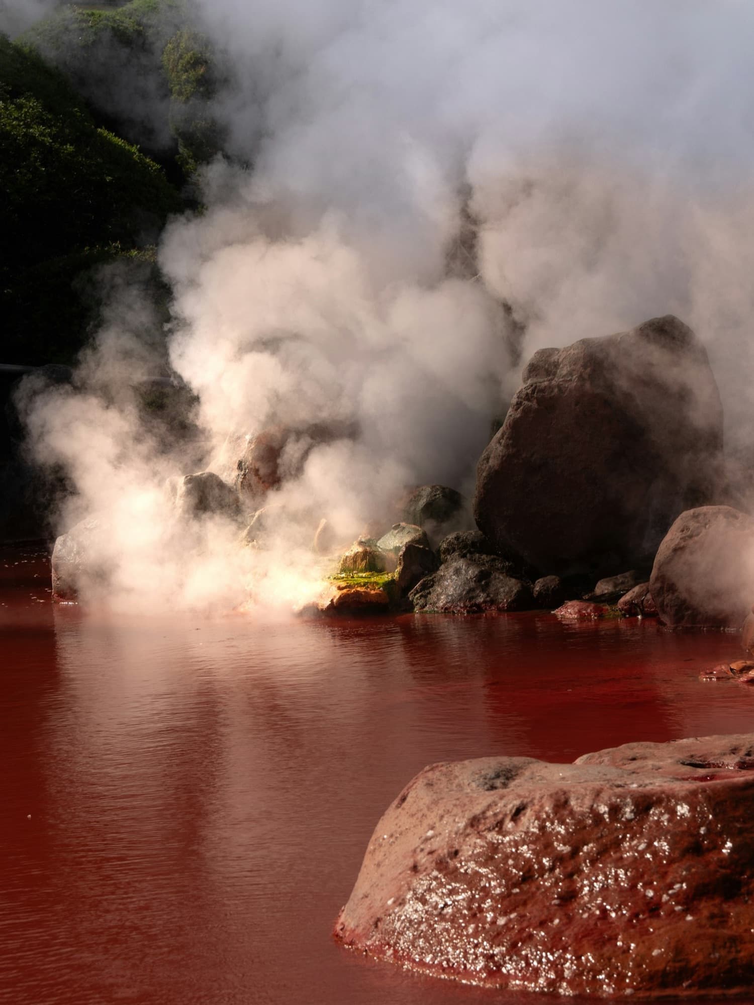 Il "hell" rosso di Beppu, una sorgente termale dall'acqua rosso vivo con il vapore che sale, a Kyushu