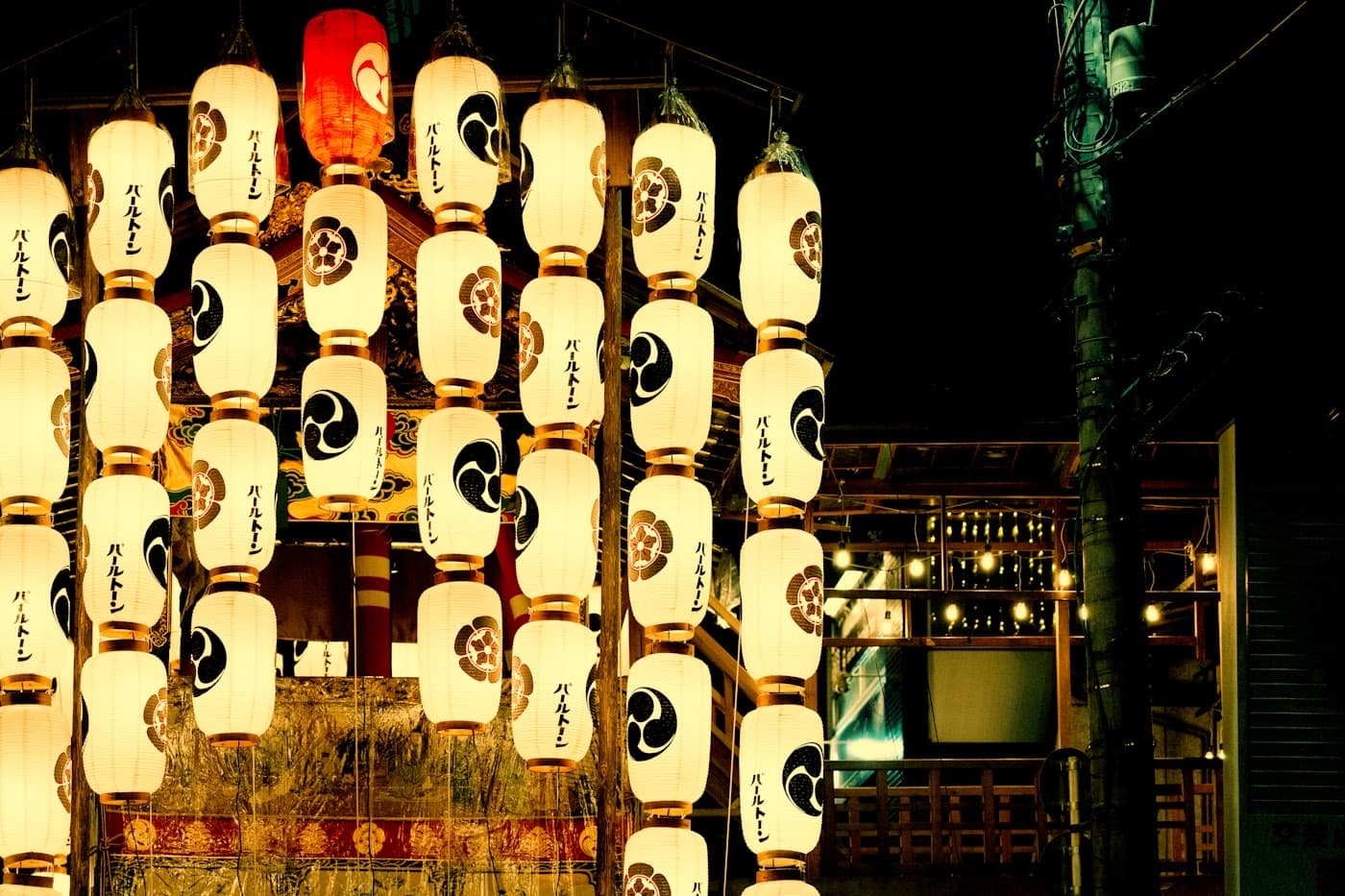 Le lanterne di carta illuminate di un carro da festival giapponese di notte, con gli stemmi e le scritte in giapponese