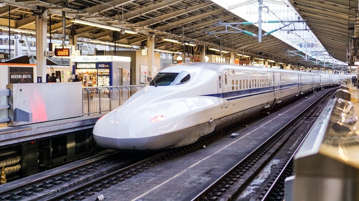 Uno shinkansen bianco fermo al binario di una stazione