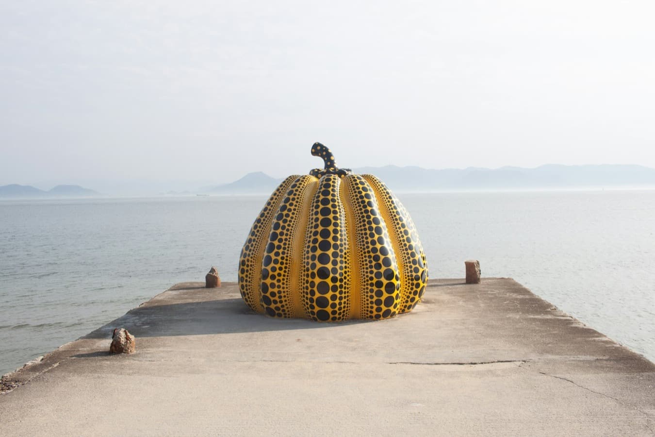 La zucca gialla a pois di Yayoi Kusama sul molo di Naoshima, con il mare alle spalle