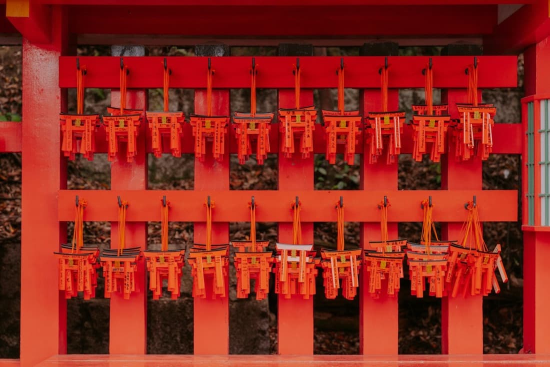 Tavolette votive a forma di torii rosso appese a un santuario giapponese