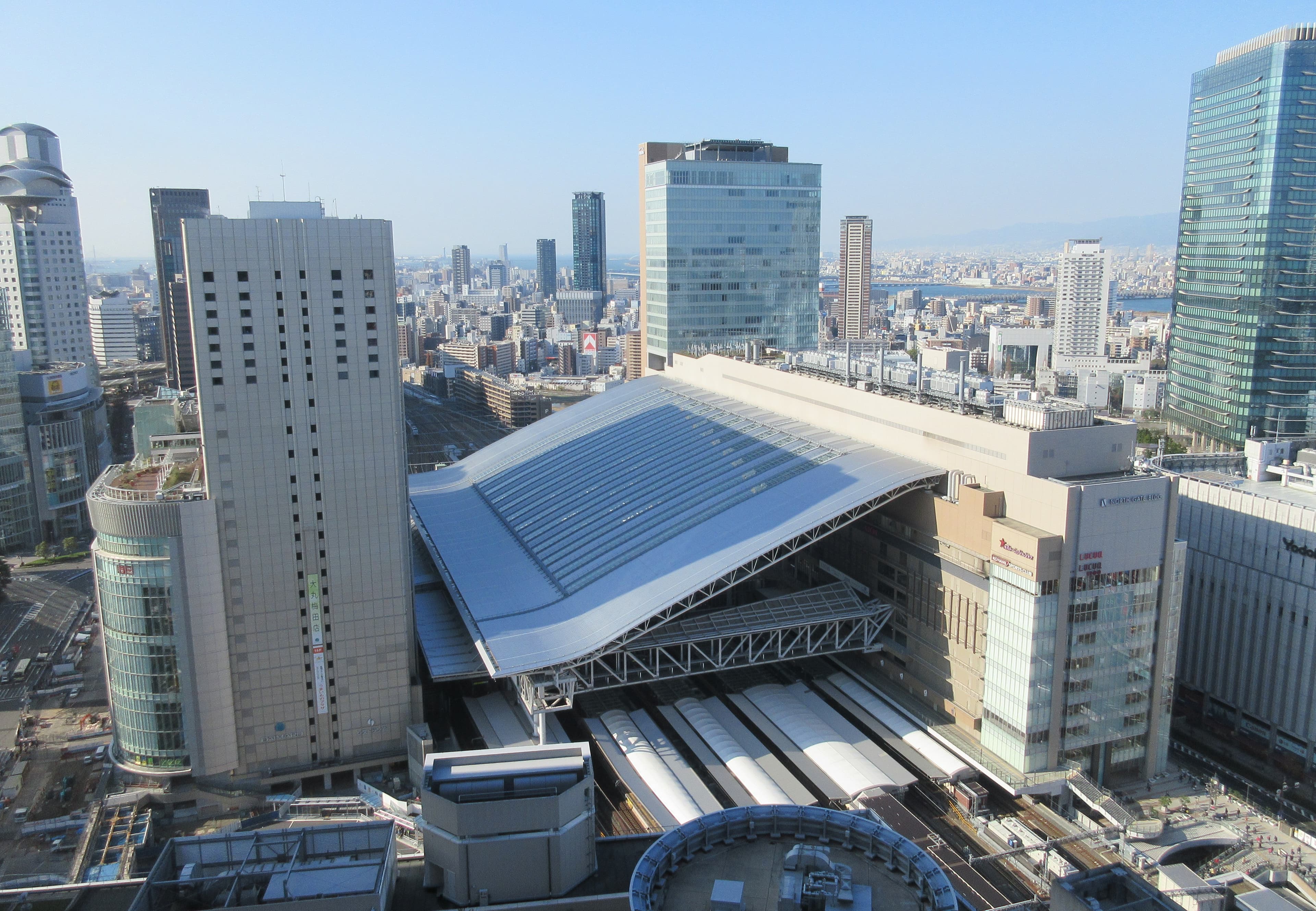 La stazione di Osaka con le insegne delle diverse compagnie ferroviarie e i binari JR in evidenza