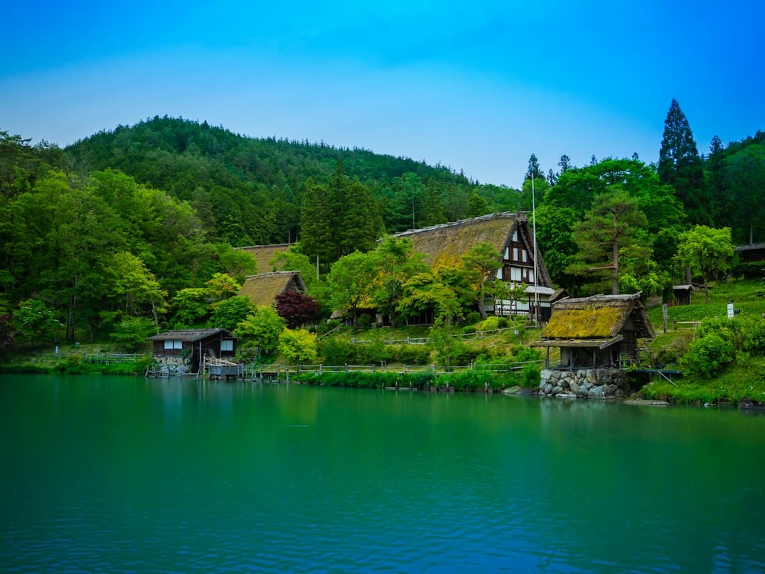 Le case dal tetto di paglia di Hida no Sato, il villaggio-museo vicino a Takayama, affacciate su un laghetto verde