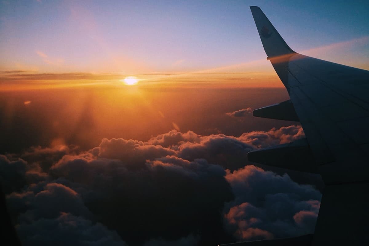 L'alba vista dal finestrino di un aereo, sopra le nuvole