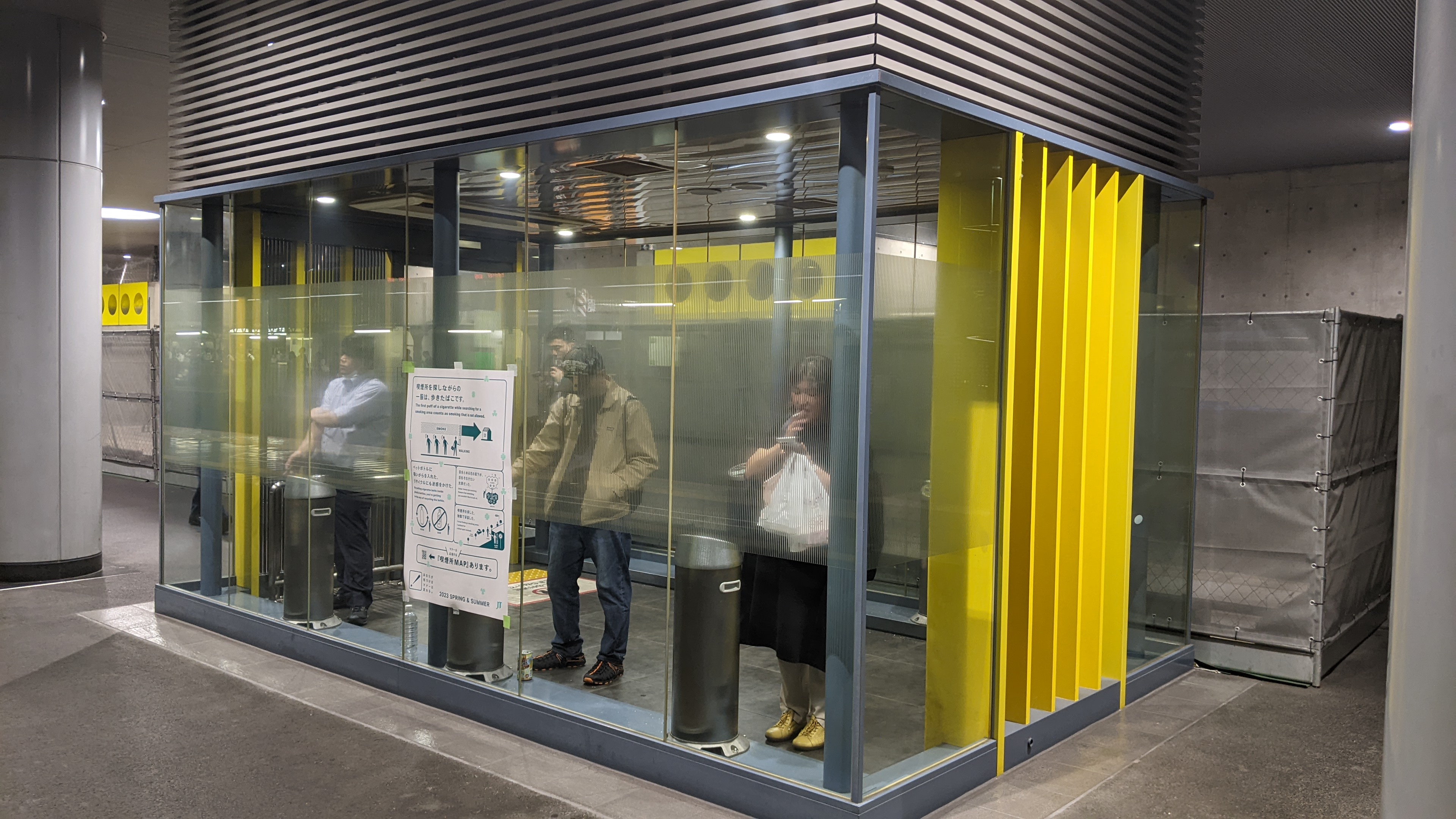 Una mano che regge uno smartphone con un'app di navigazione ferroviaria giapponese aperta su una schermata con orari e binari