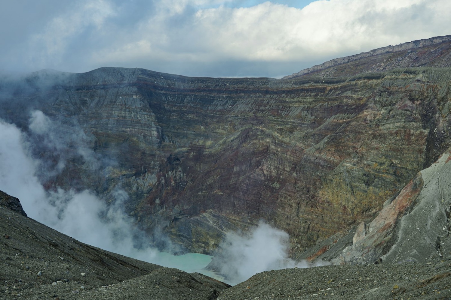 Il cratere attivo del Nakadake, sul Monte Aso, con il laghetto turchese e il vapore che sale dalle pareti di roccia