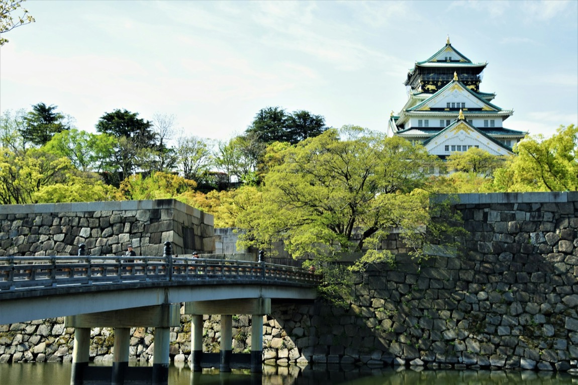 Il castello di Osaka con i suoi alberi di ciliegio in fiore, riflessi nel fossato
