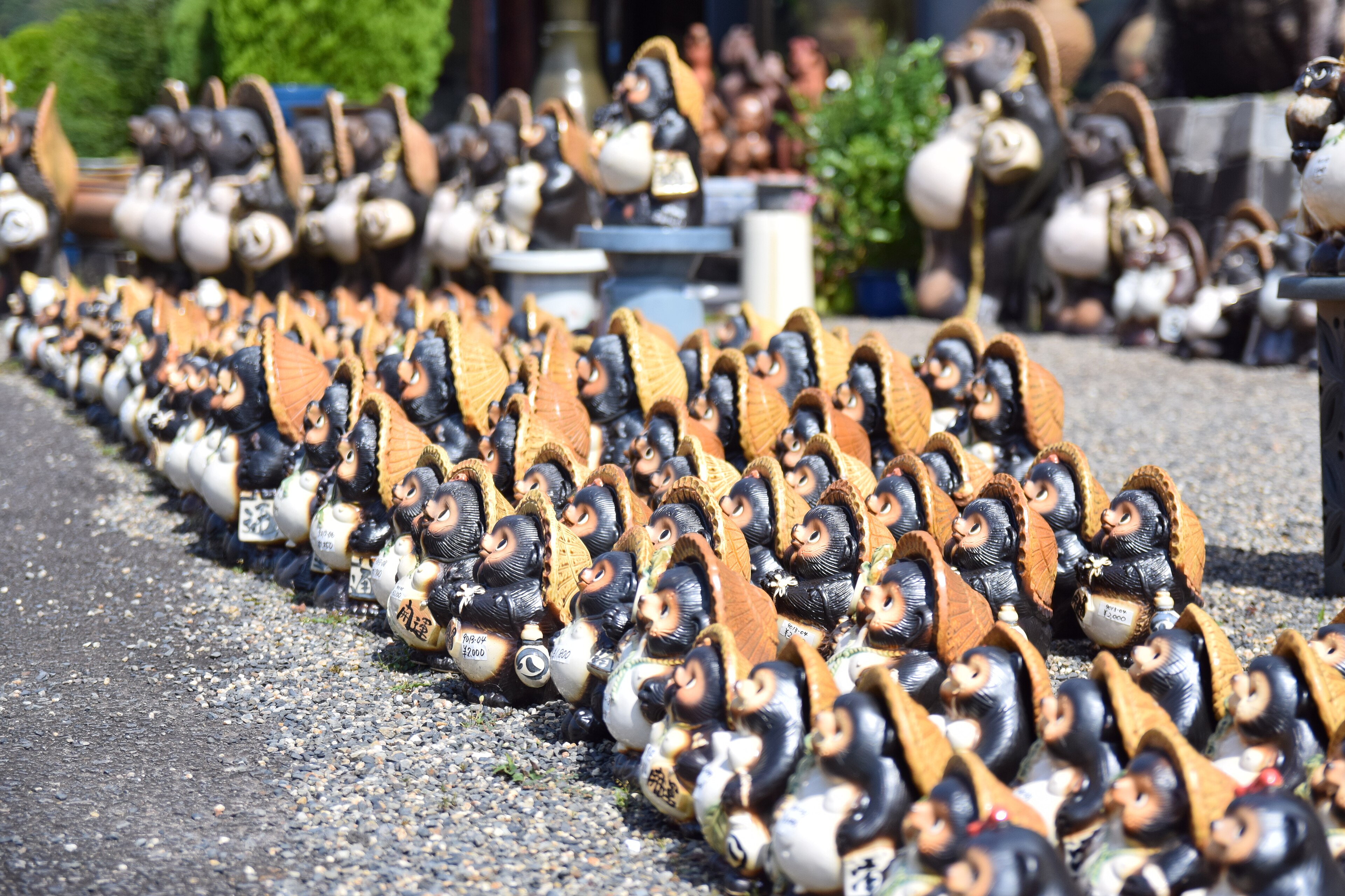 Tanuki in ceramica di Shigaraki, simbolo di fortuna esposto davanti a una bottega