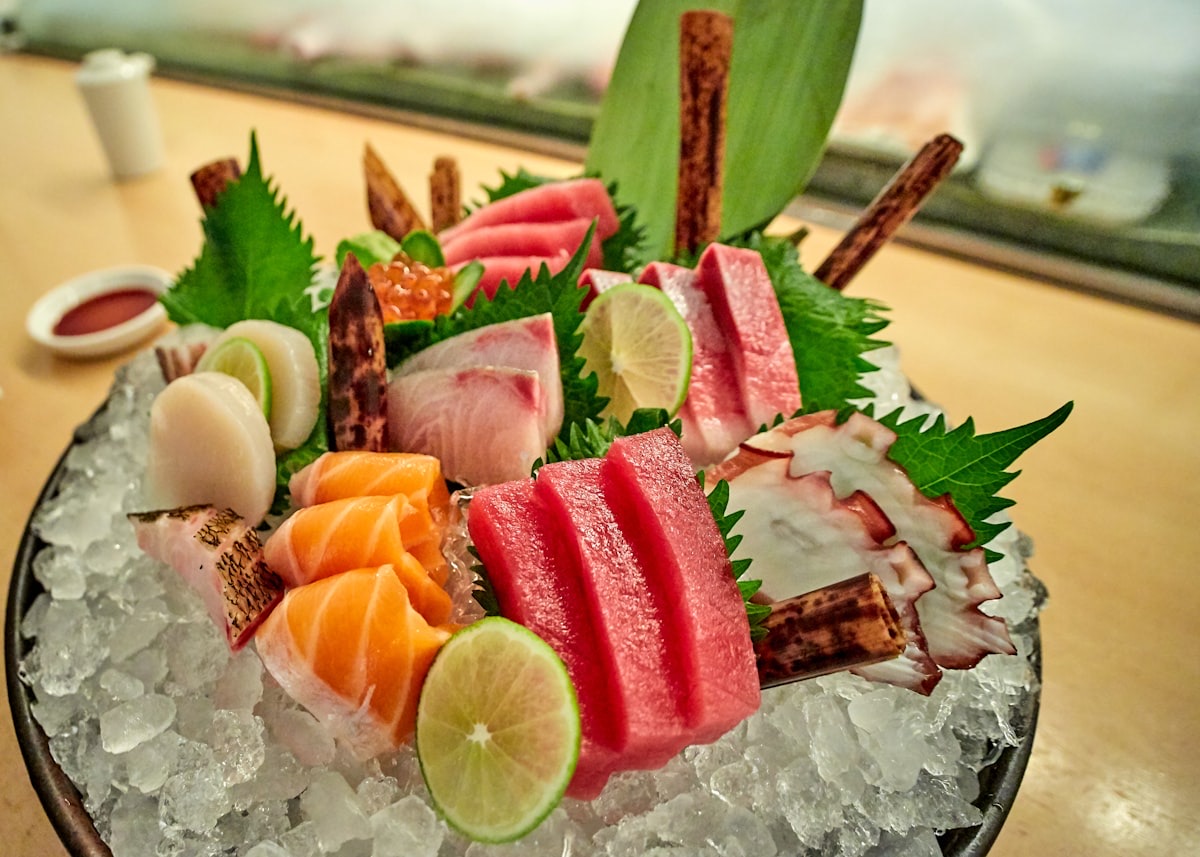 Un piatto di sashimi su ghiaccio: tonno, salmone, capesante e polpo