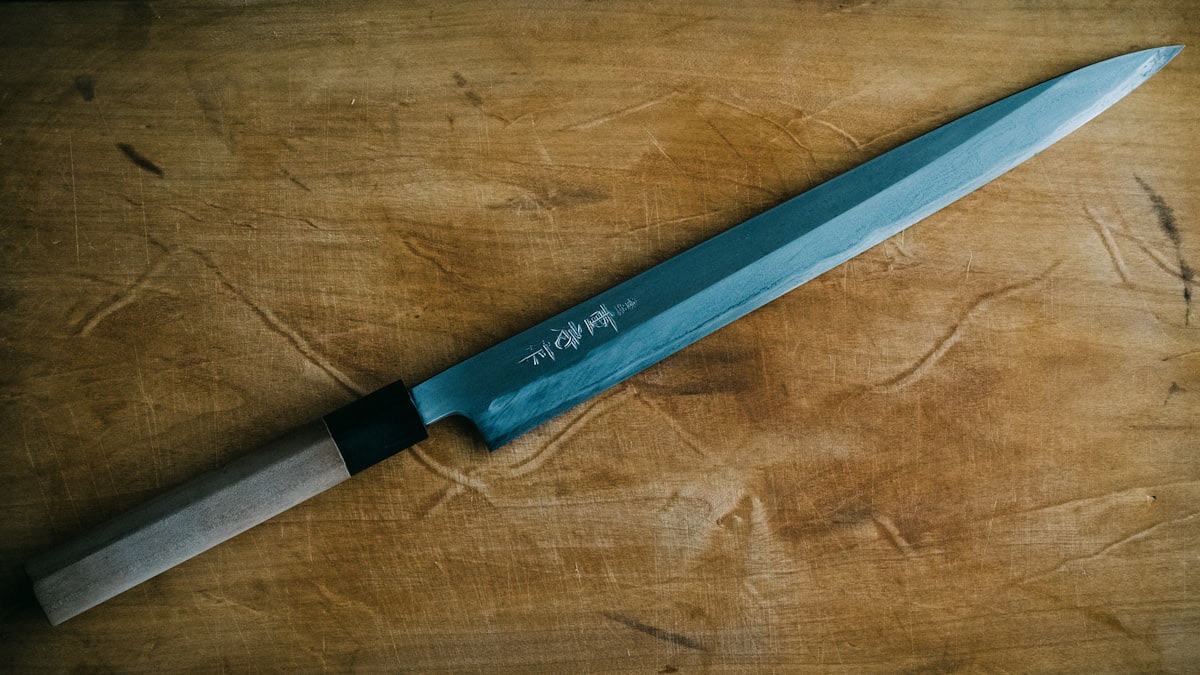 Un coltello giapponese da cucina appoggiato su un tagliere di legno