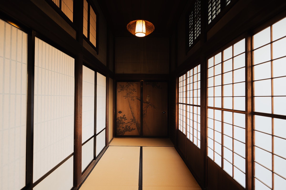 Un interno tradizionale giapponese con tatami, porte scorrevoli di carta e una porta dipinta