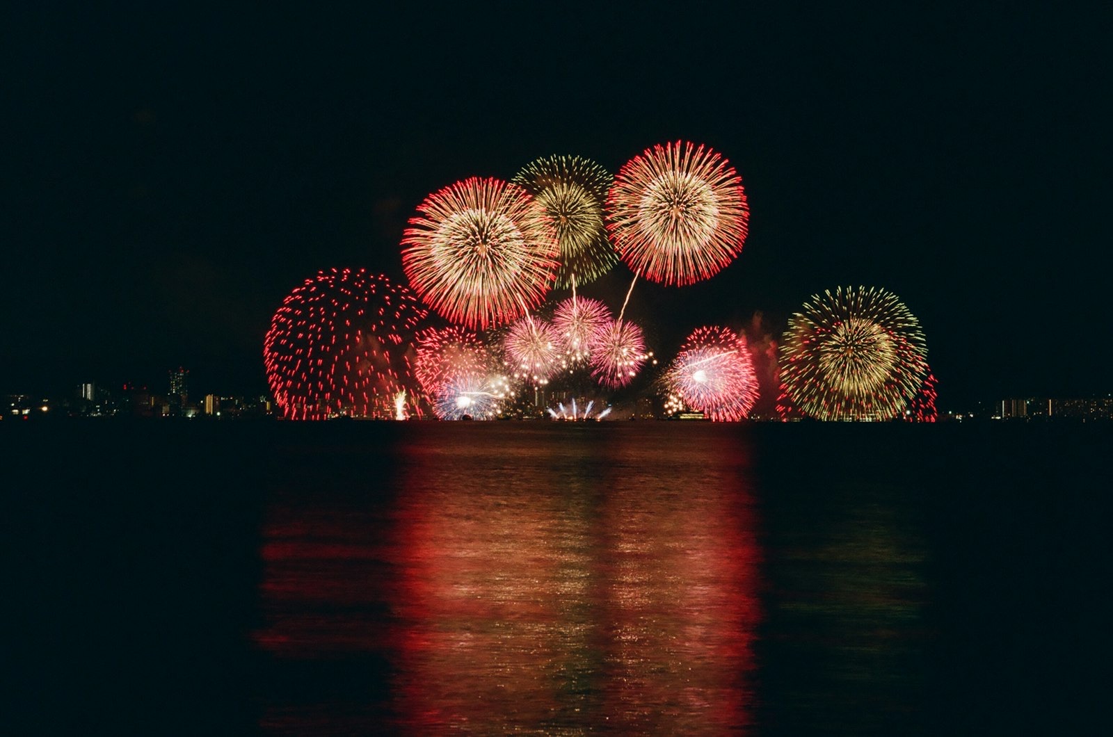 Ragazze in yukata guardano i fuochi d'artificio estivi che si aprono nel cielo notturno del Giappone