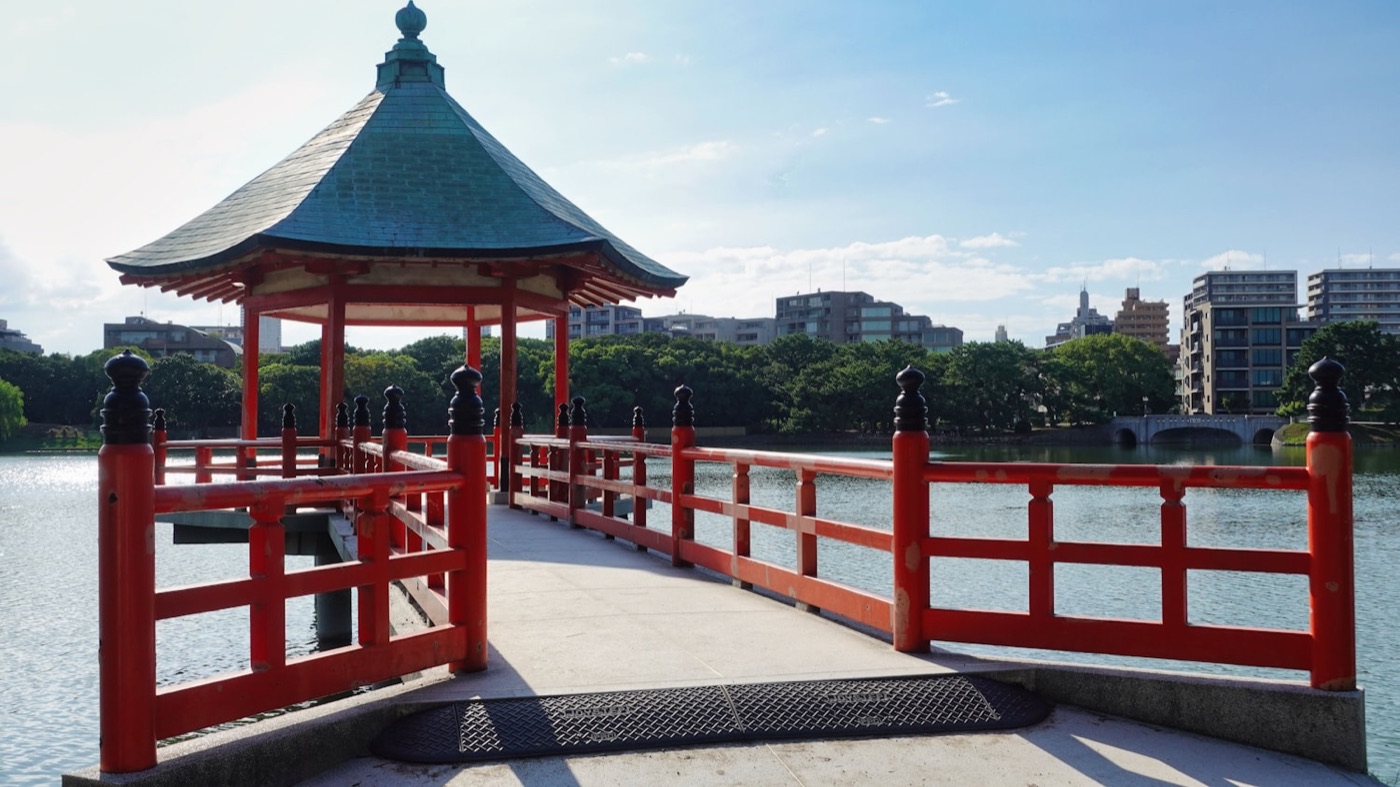 Il padiglione rosso sul lago del parco Ohori a Fukuoka, con lo skyline della città sullo sfondo
