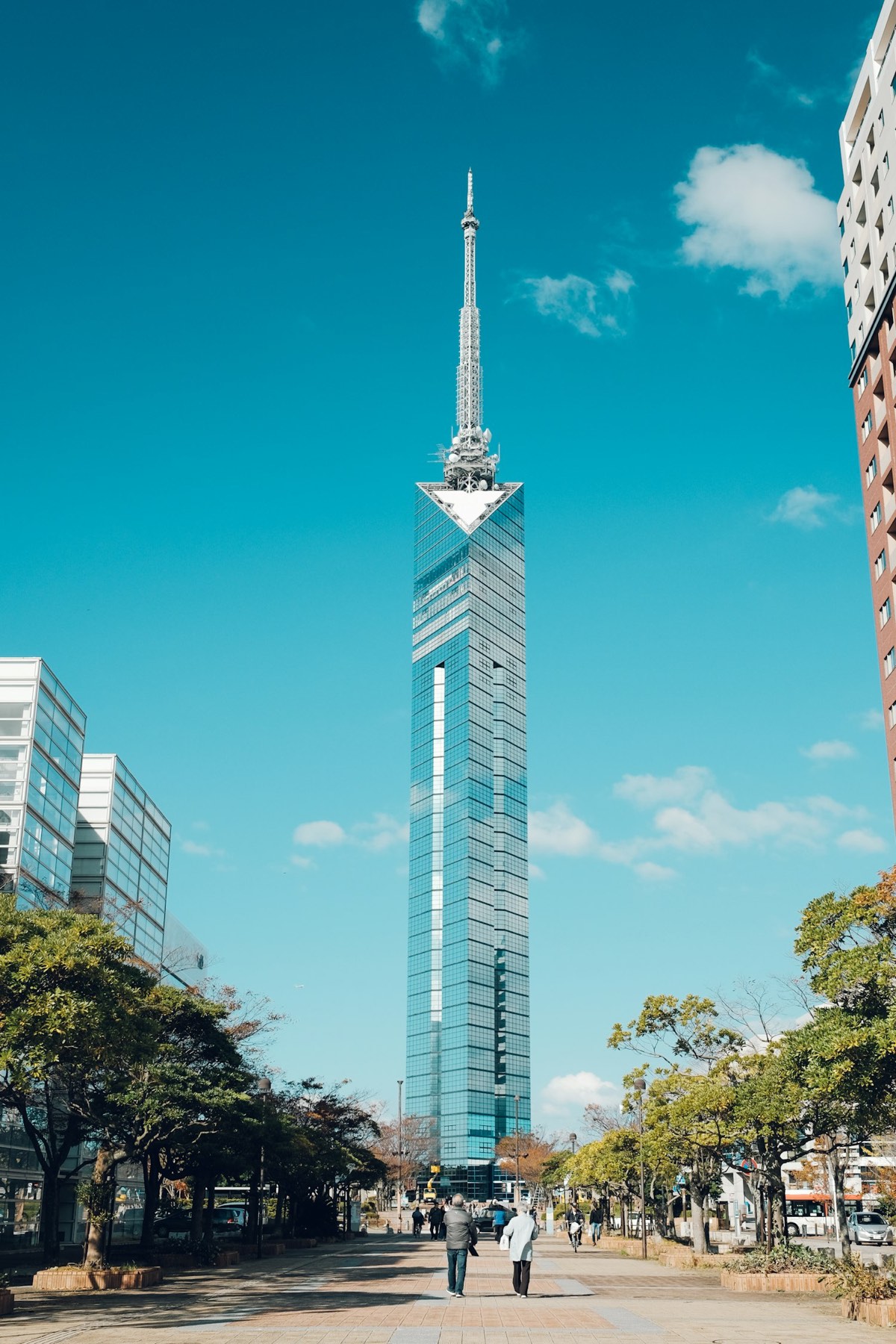La Torre di Fukuoka, alta torre a specchi triangolare, vista dal viale alberato di Momochi