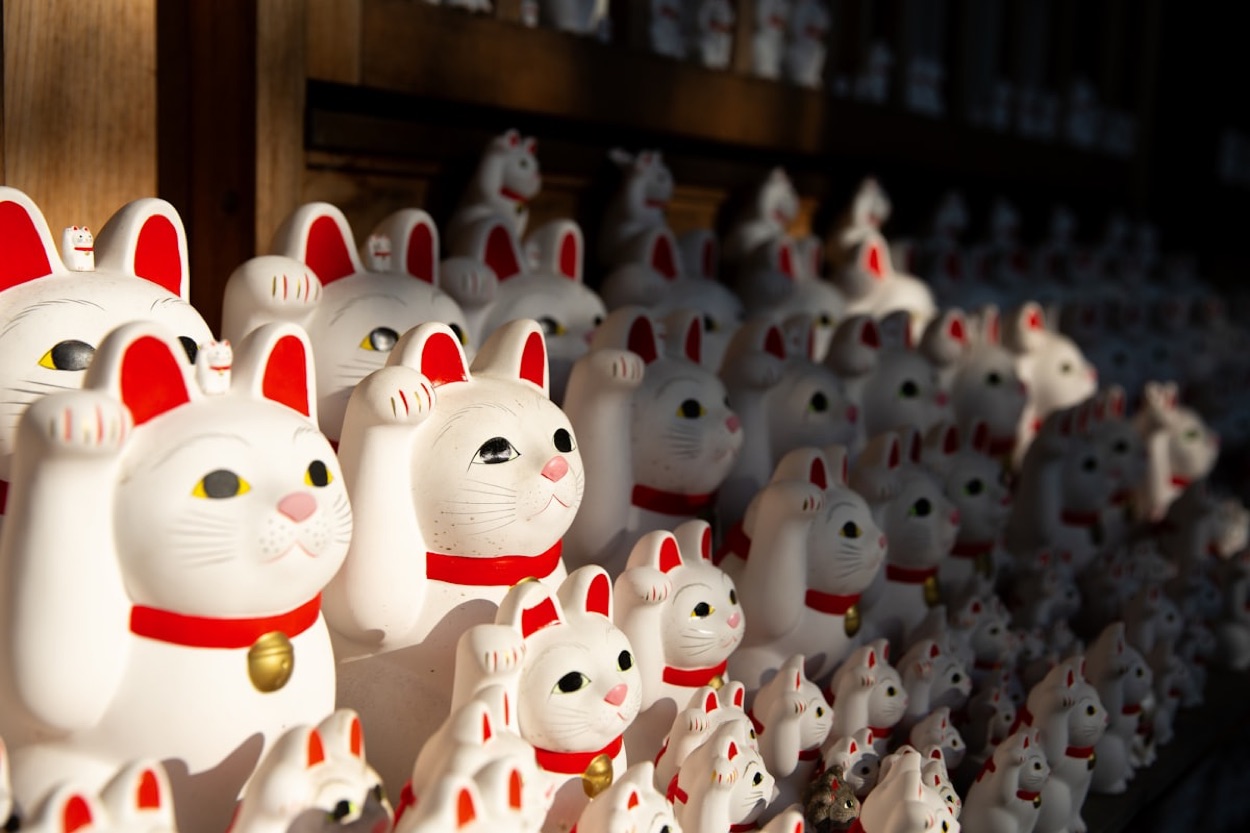 Centinaia di statuine bianche di maneki-neko, il gatto portafortuna, allineate al tempio Gotokuji di Tokyo