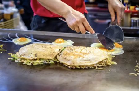 Okonomiyaki di Hiroshima cotto sulla piastra