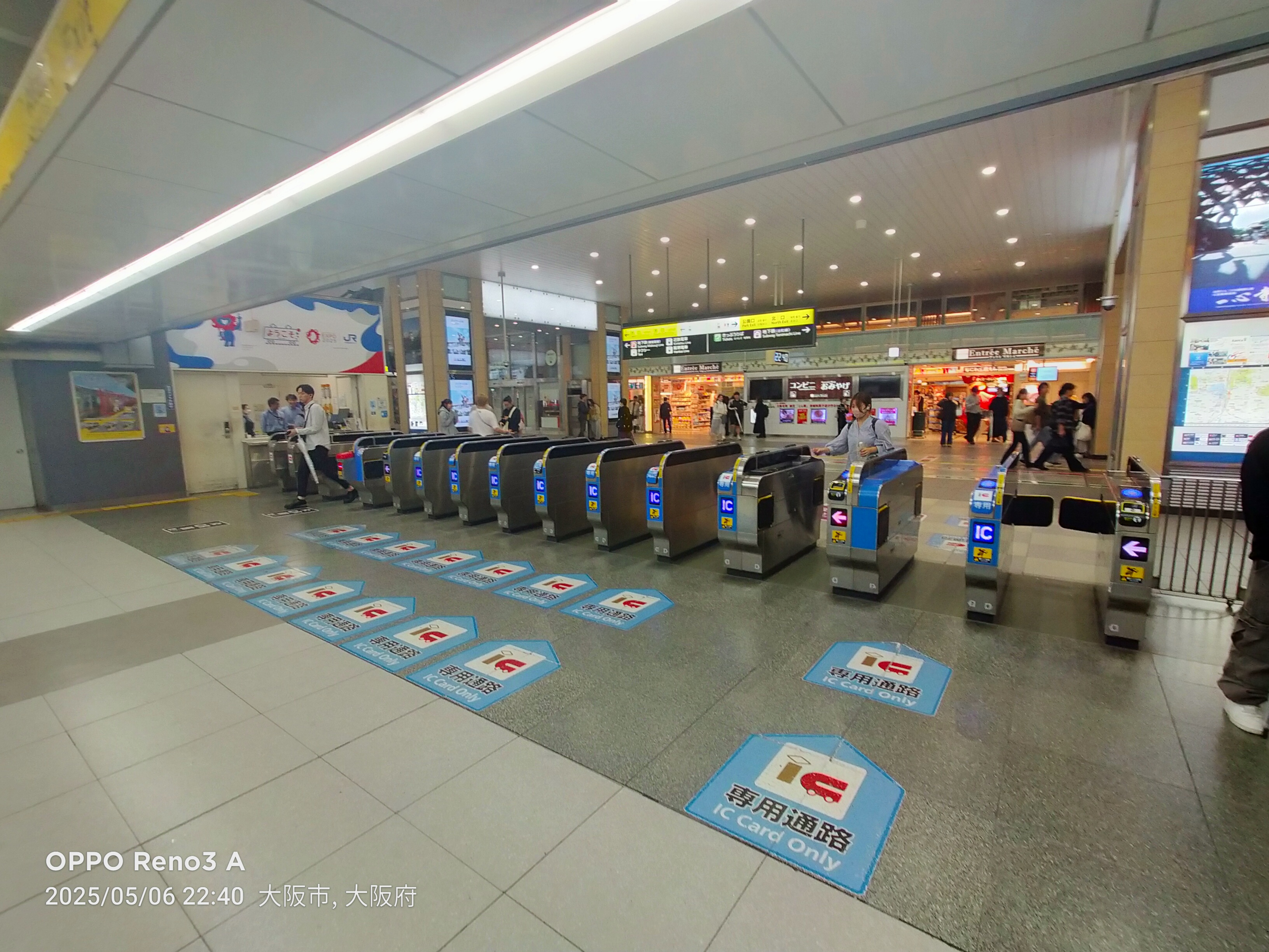 I tornelli automatici di una stazione giapponese con i lettori IC card blu, con i viaggiatori che passano appoggiando la carta