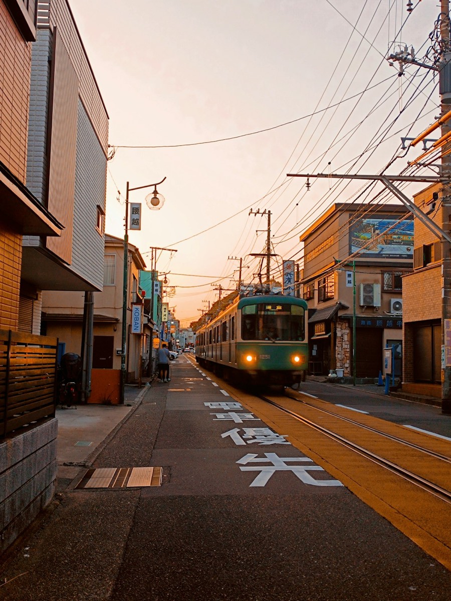 L'Enoden, il trenino verde, corre lungo la strada tra le case a Koshigoe, Kamakura