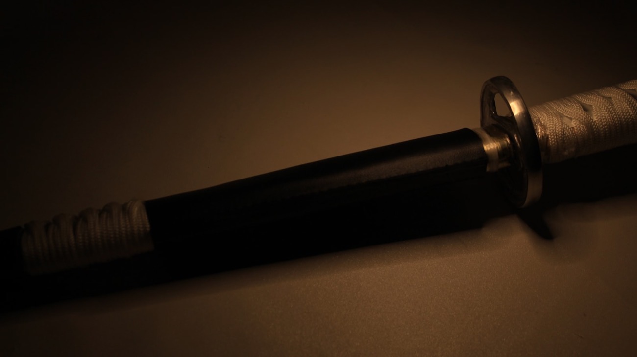 Il dettaglio dell'elsa di una katana, con la guardia (tsuba) e l'impugnatura avvolta di cordino bianco