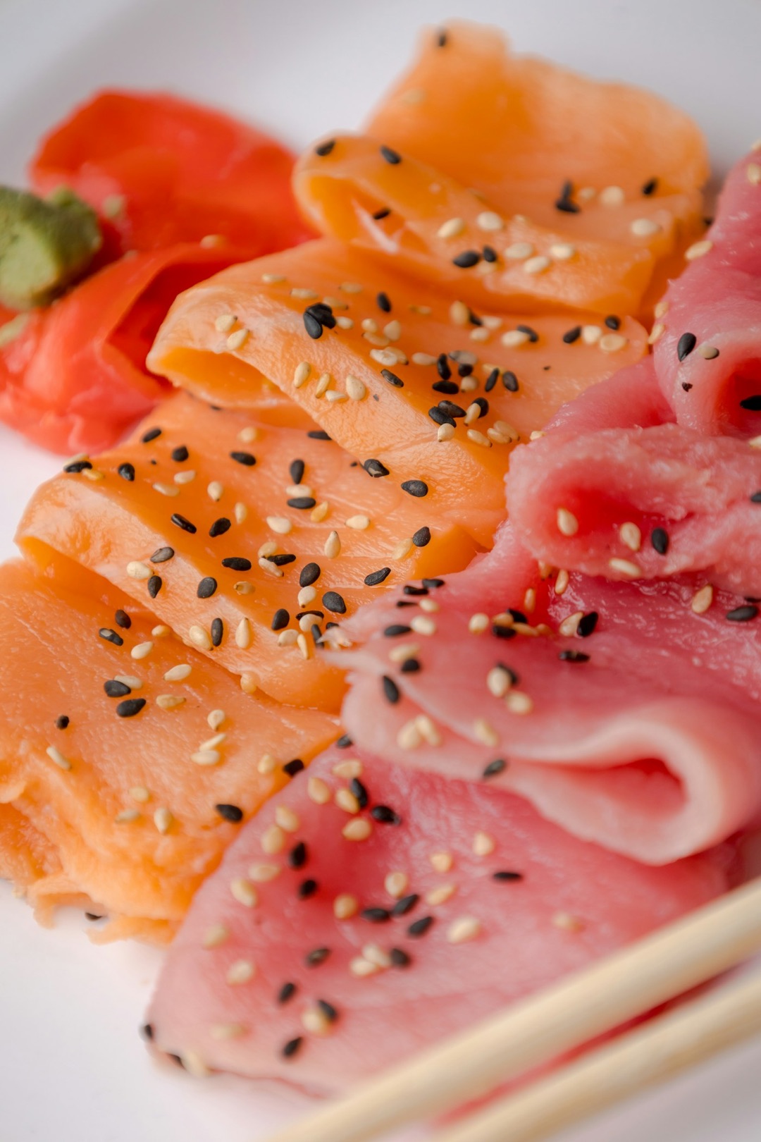 Un piatto di sashimi su ghiaccio: tonno, salmone, capesante e polpo