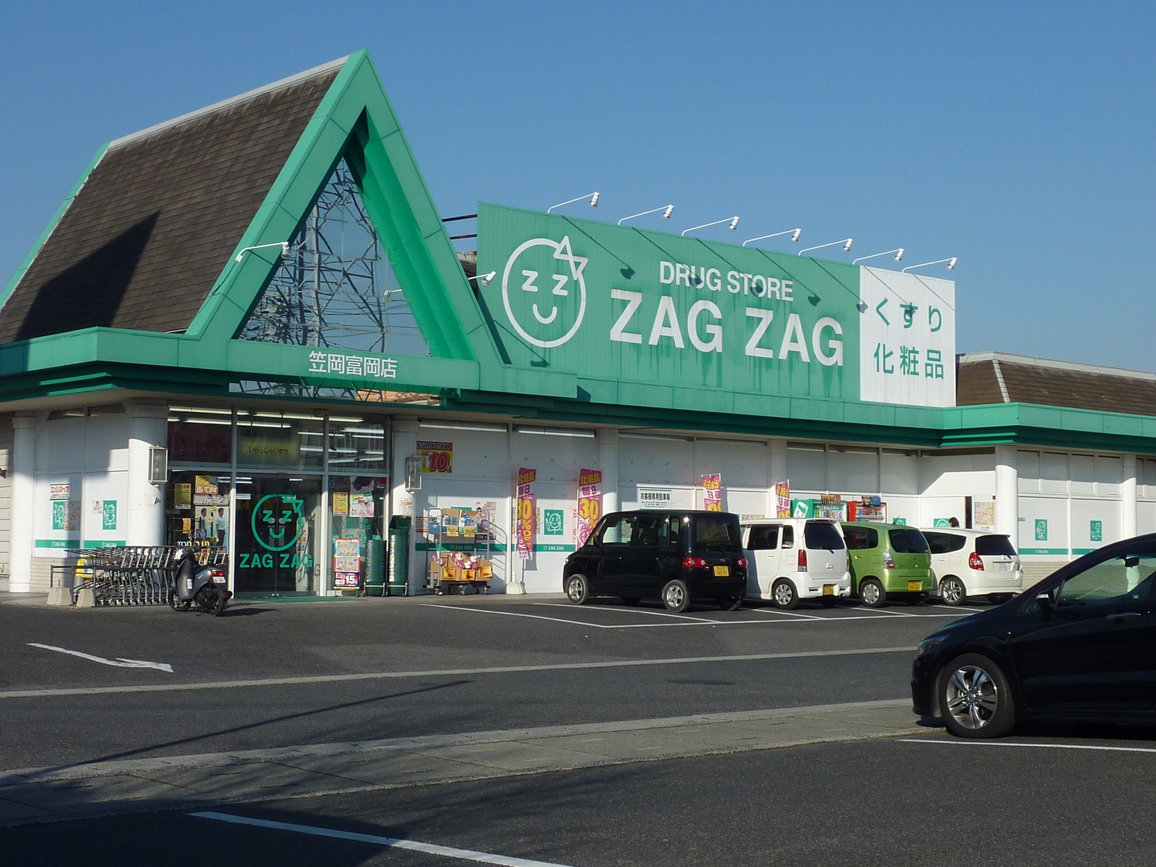 L'esterno di un drugstore giapponese con l'insegna verde e l'indicazione くすり (kusuri, medicine)