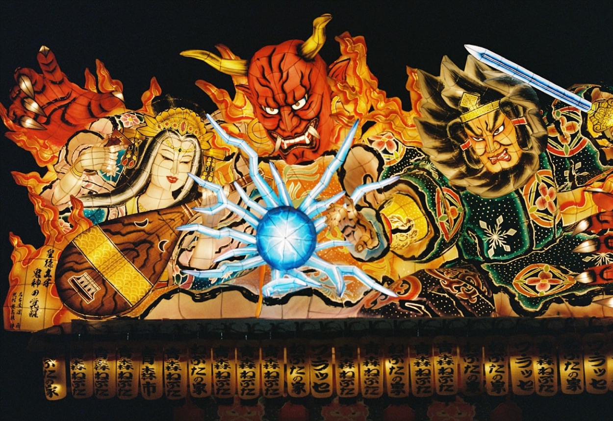Un enorme carro luminoso del Nebuta Matsuri di Aomori, con figure dipinte di guerrieri e demoni e le lanterne con la scritta Aomori Nebuta