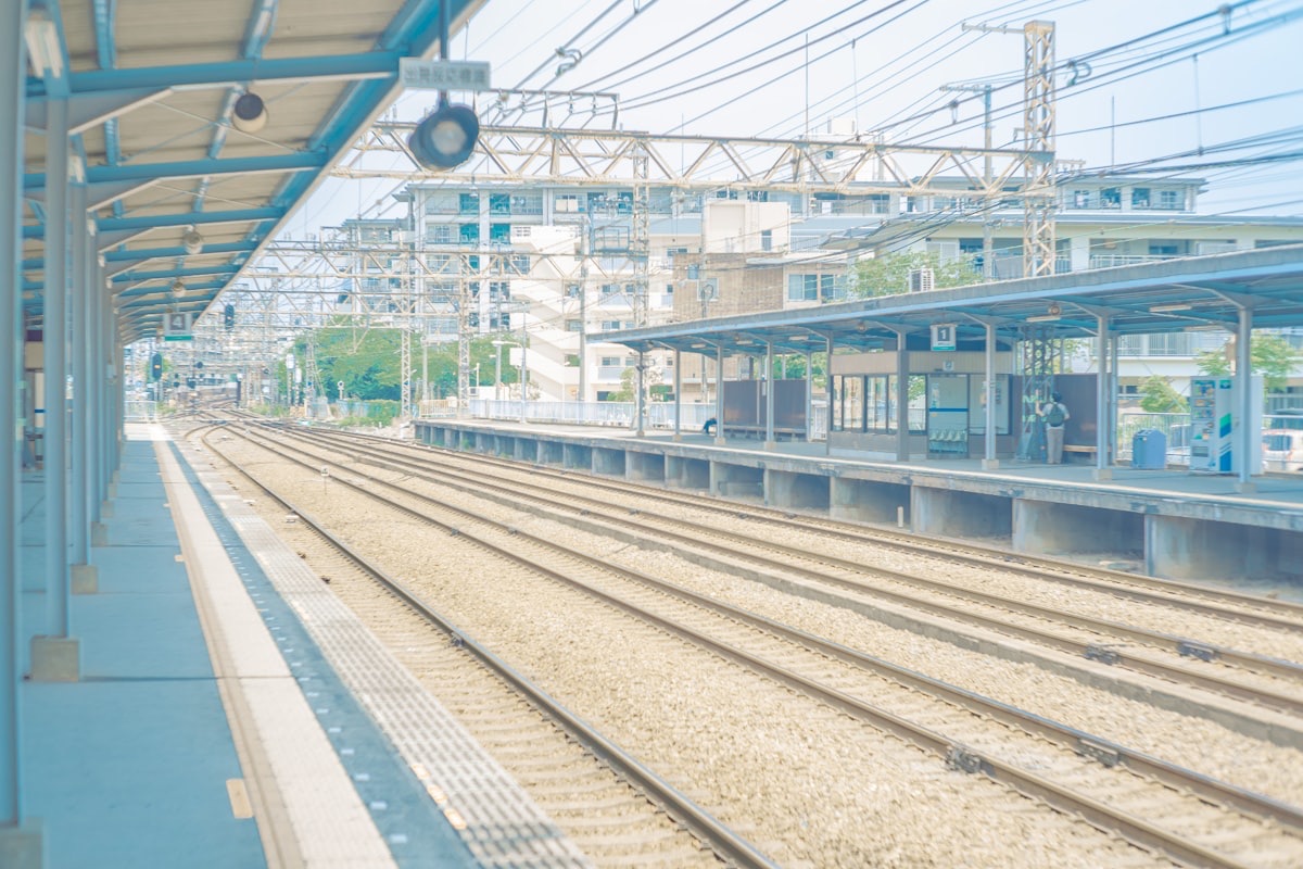 Una banchina di una stazione giapponese di periferia, con i binari