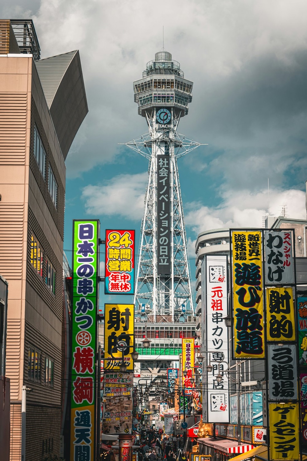 La torre Tsutenkaku di Osaka che svetta sopra le vie di Shinsekai piene di insegne al neon colorate