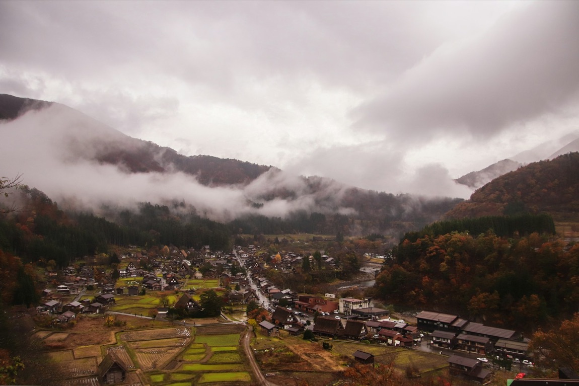 Il villaggio di Shirakawa-go visto dall'alto, con le case dai tetti di paglia tra le montagne verdi