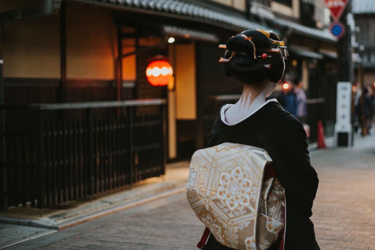 Una maiko di spalle in una via di Kyoto, con l'obi ricamato