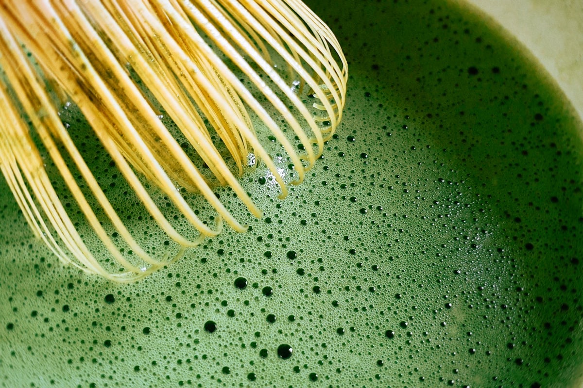 Matcha appena montato con la frusta di bambù, in primo piano