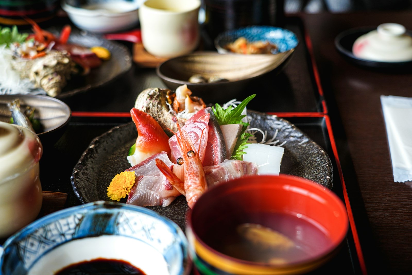 Un vassoio di cena kaiseki con piccole porzioni disposte in ciotole di ceramica diverse