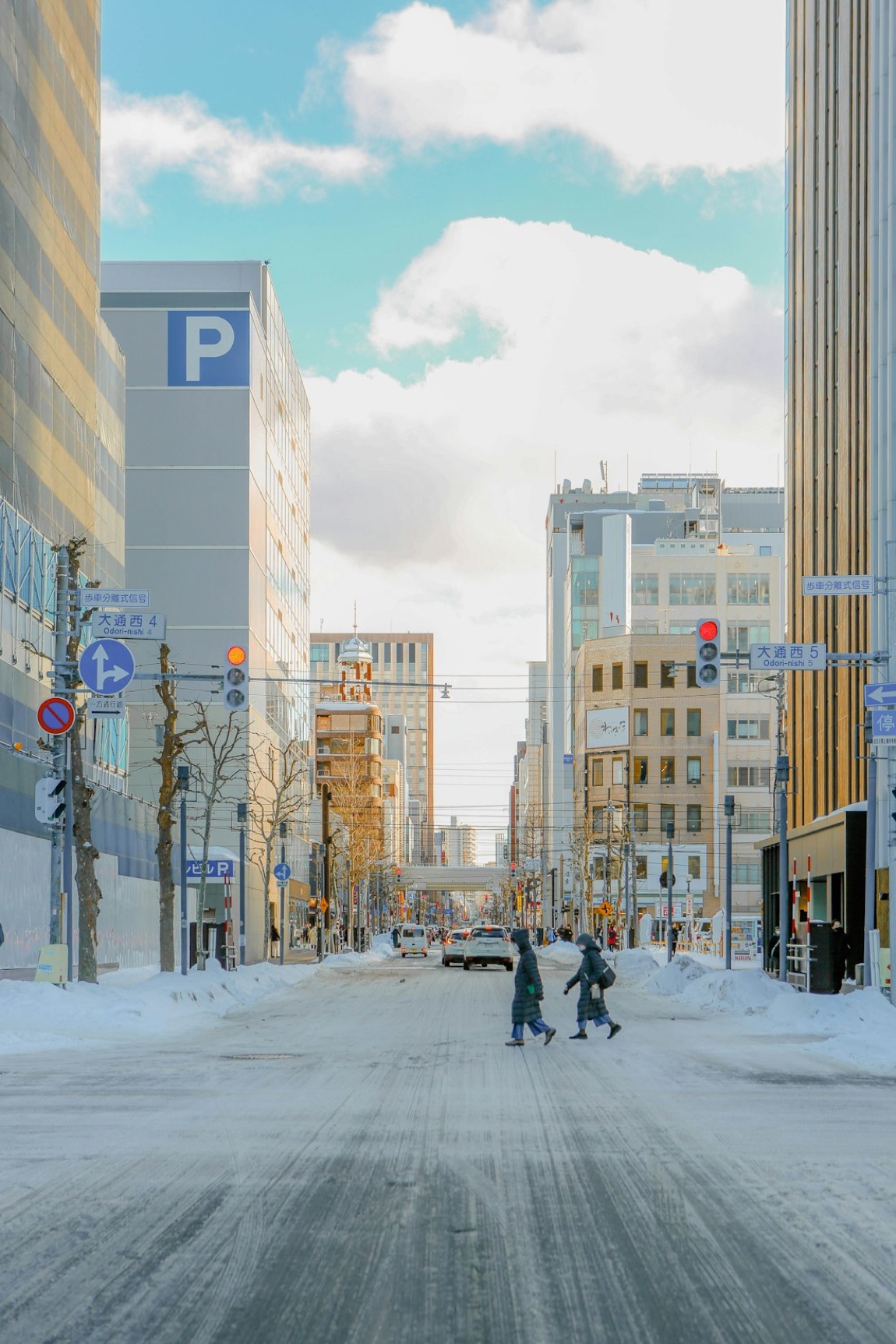 Una via del centro di Sapporo in inverno, con la neve, i cartelli di Odori e i palazzi