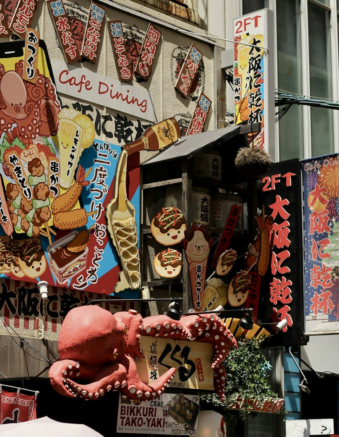 Il grande polpo rosso dell'insegna di una taverna di takoyaki a Dotonbori, Osaka, tra insegne coloratissime