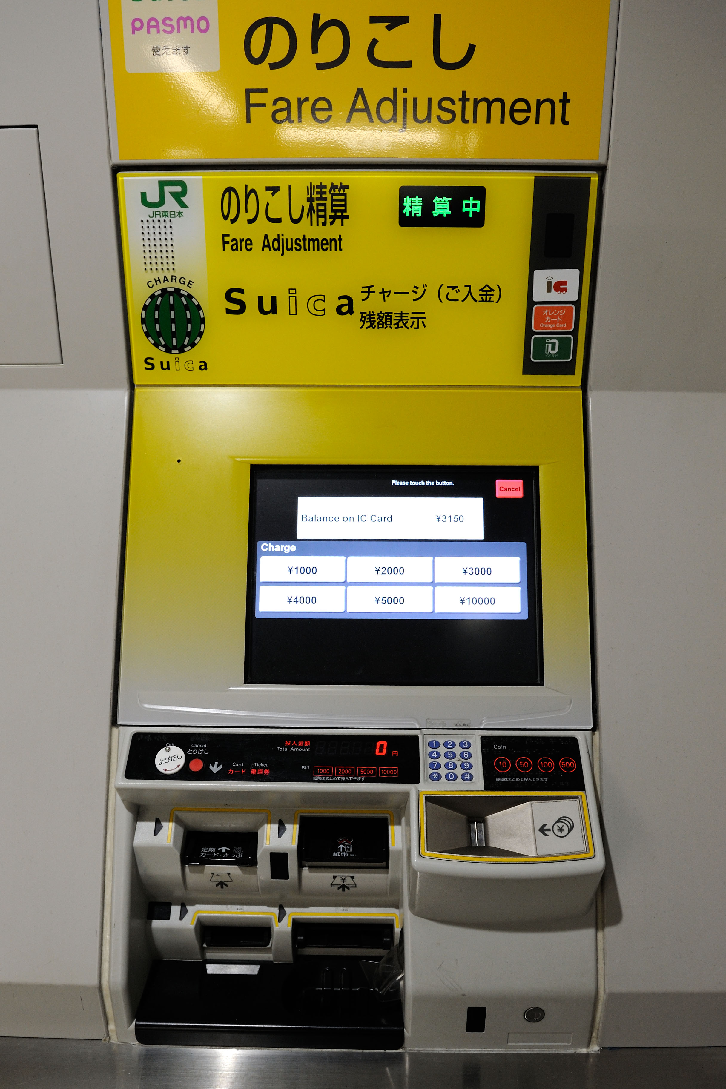 Il pannello di ricarica della Suica in una stazione giapponese: schermo giallo con le opzioni di ricarica in yen e il logo Suica verde
