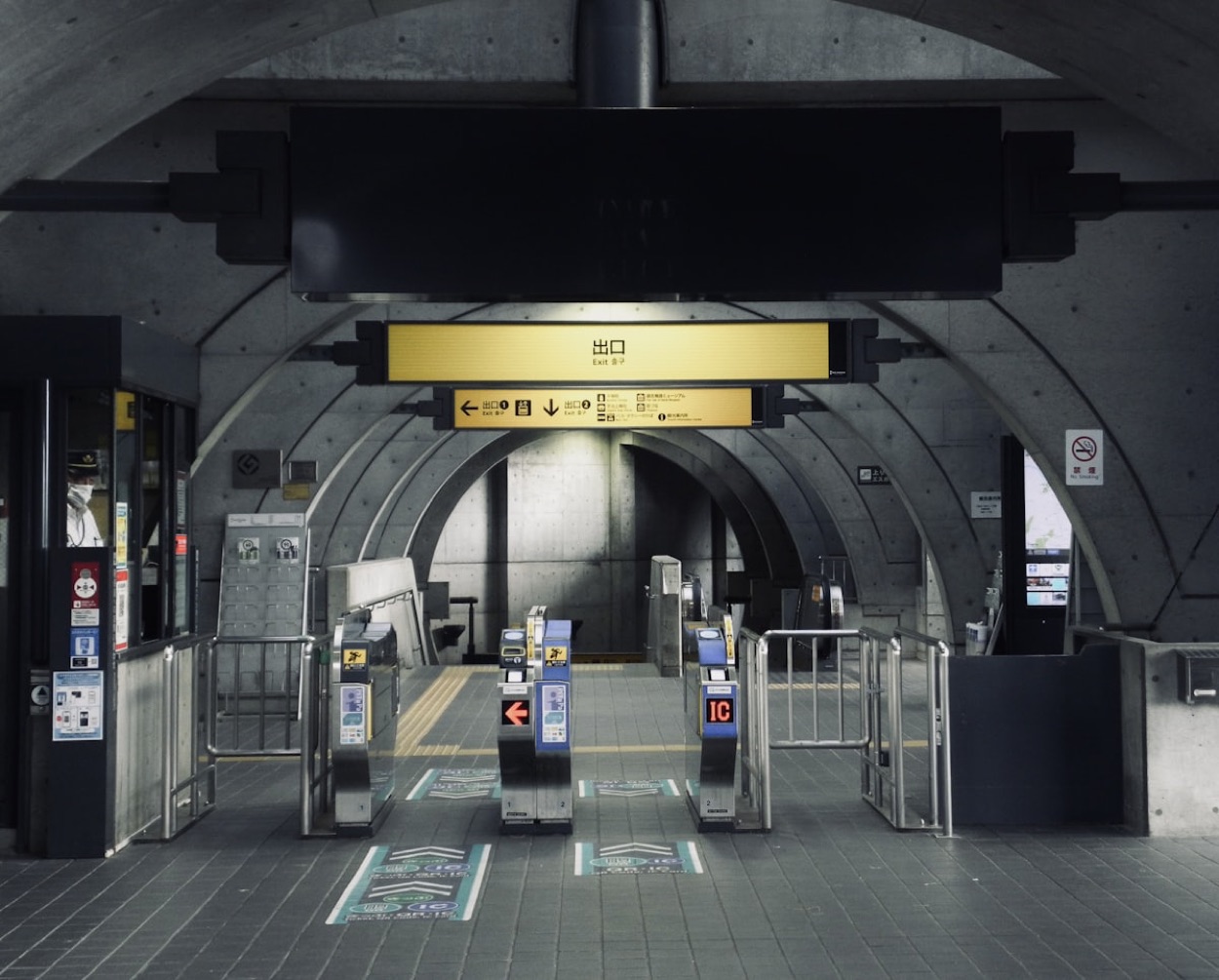 I tornelli di una stazione giapponese con i lettori IC blu e l'insegna dell'uscita in giapponese