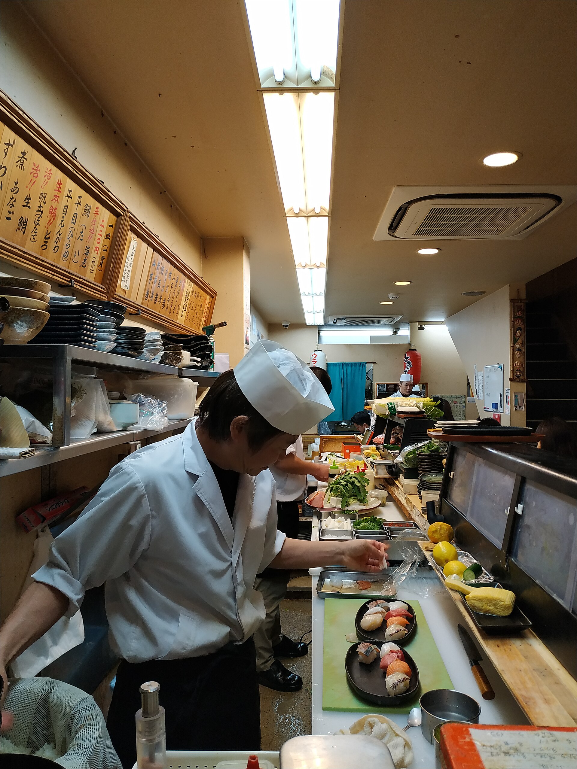 Lo chef di sushi che prepara i nigiri al bancone
