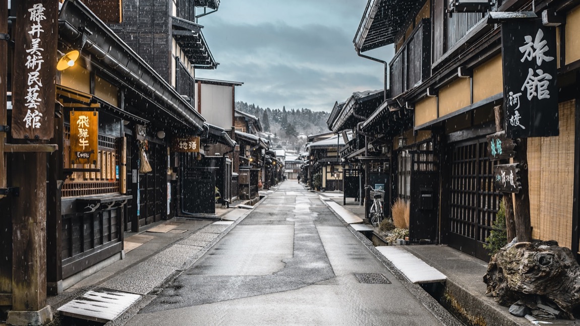 Una via della città vecchia di Takayama con le case di legno scuro e le insegne tradizionali