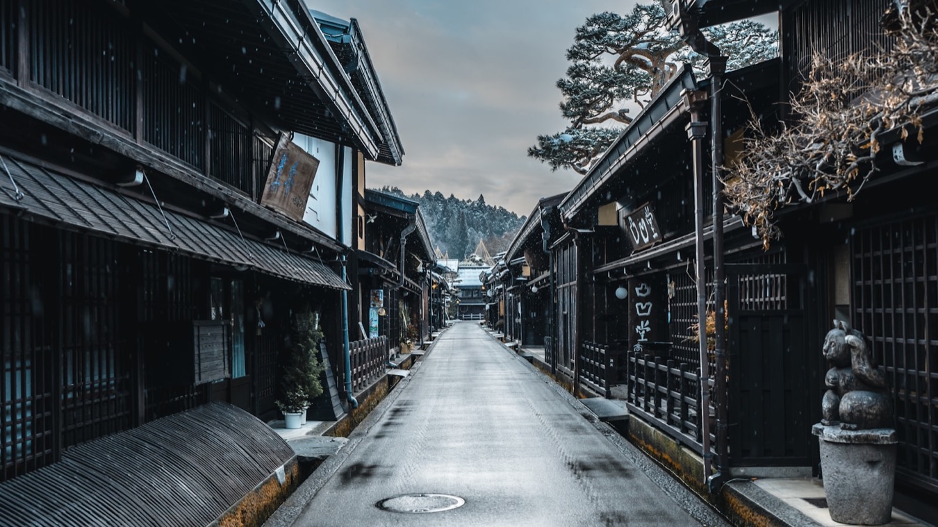 La via antica di Sanmachi a Takayama, con le case di legno scuro e la neve, tra le montagne