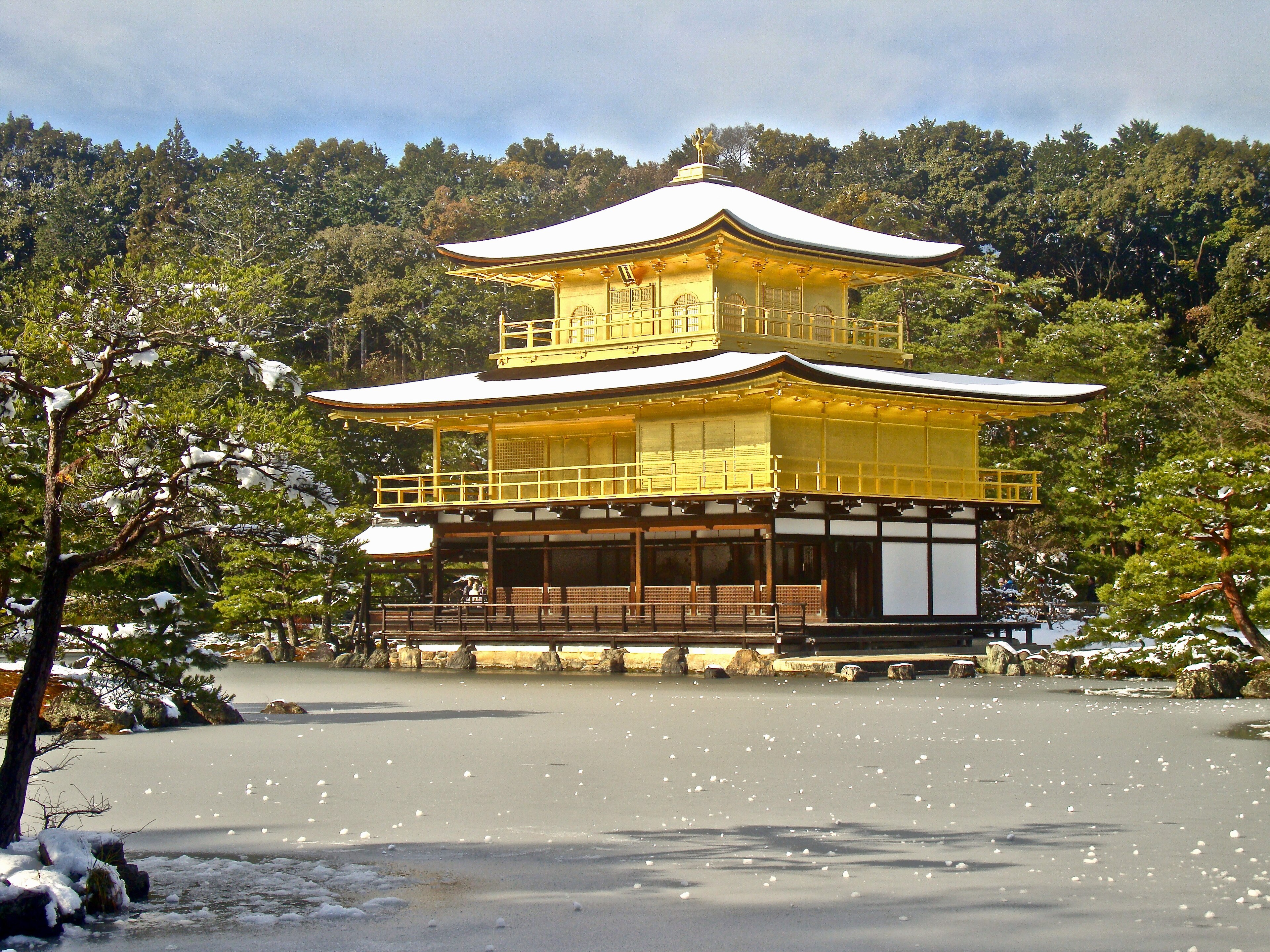 Il Kinkakuji riflesso nel lago in inverno con la neve sui tetti dorati