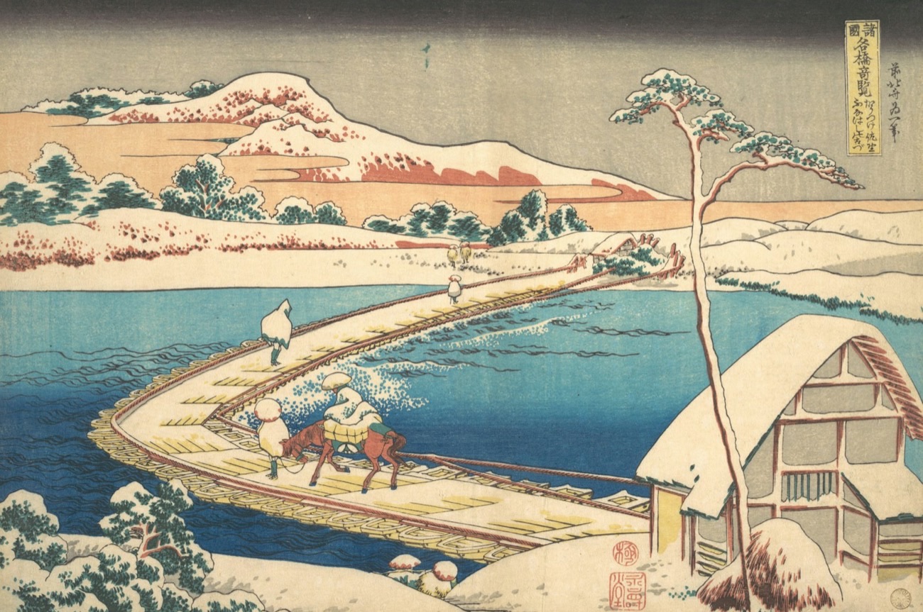 Una stampa ukiyo-e di Hokusai: un ponte di barche innevato su un fiume azzurro, con viaggiatori, un pino e monti sullo sfondo