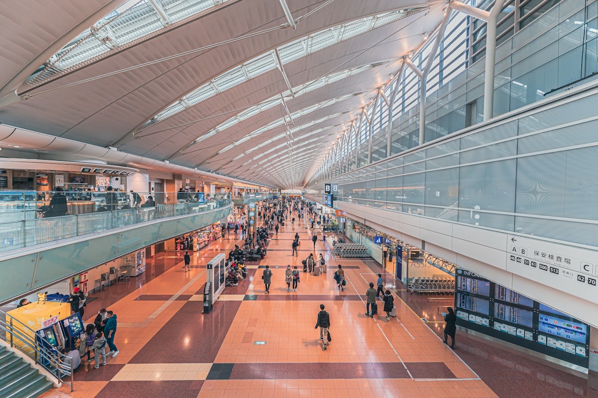 L'interno luminoso di un aeroporto giapponese, con i cartelli in giapponese e inglese