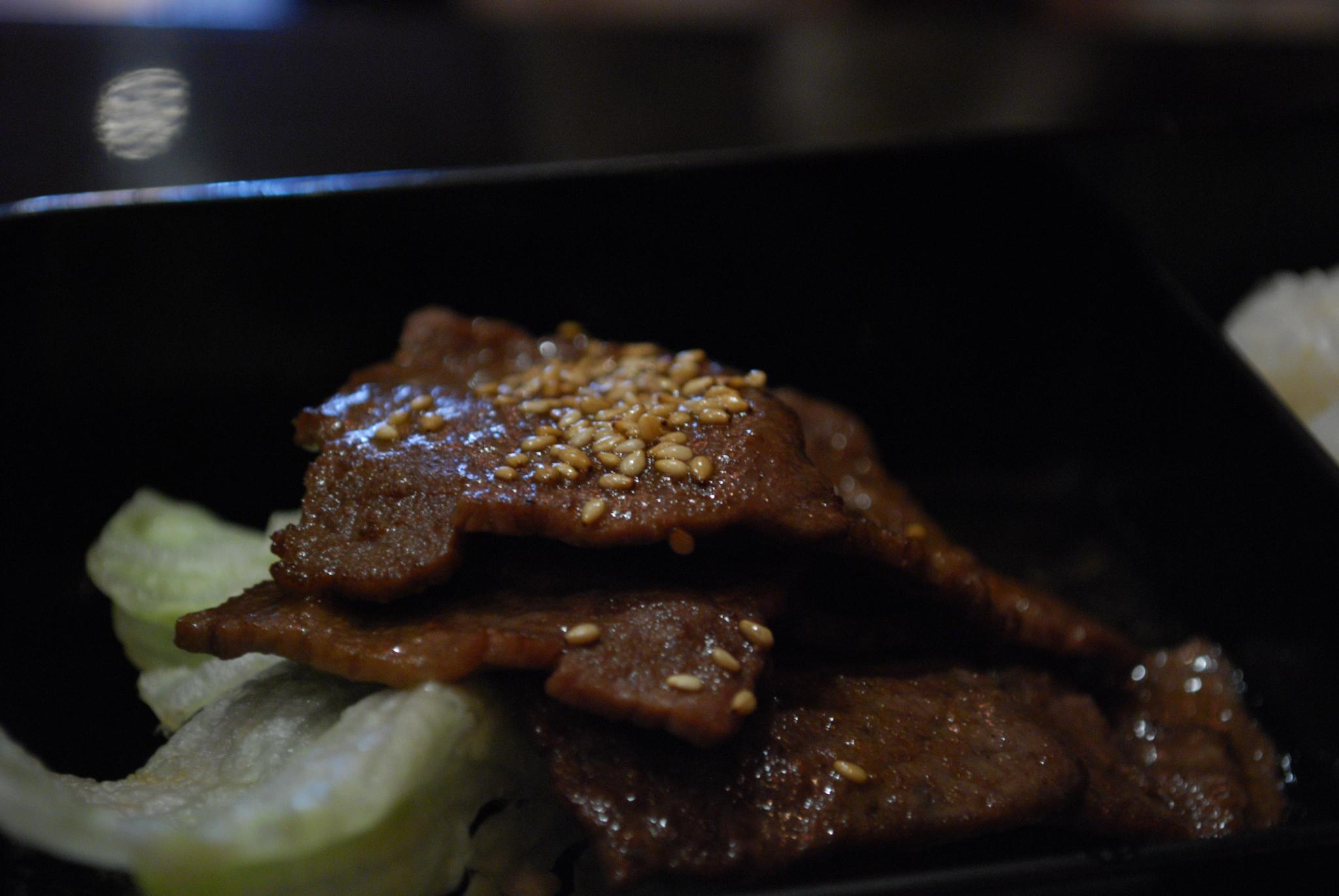Yakiniku: fettine di manzo pregiate che cuociono sulla griglia rovente integrata nel tavolo di un ristorante giapponese